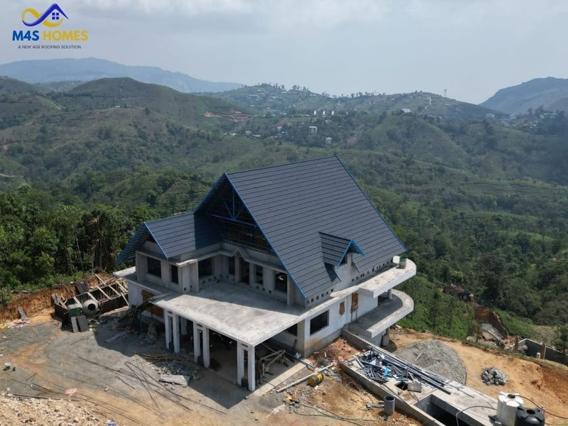 M4S Homes dark stone-coated roofing project in a high-rainfall landscape